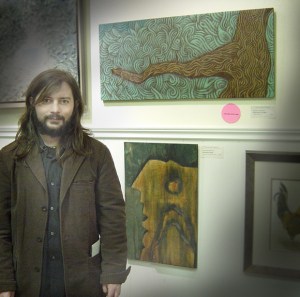 • the artist poses with his award-winning art on opening night.